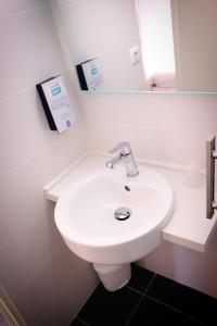 里沃萨尔特Kyriad Direct Perpignan - Aeroport的浴室设有白色水槽和镜子