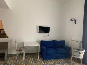 那不勒斯Specchio di Parthenope B&B的客厅设有蓝色的沙发和墙上的电视