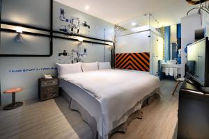 高雄NL概念商旅的卧室配有一张白色大床和电视。