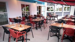 里沃萨尔特Kyriad Direct Perpignan - Aeroport的一间空餐厅,配有木桌和椅子