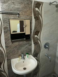 那格浦尔Hotel Relax Inn的一间带水槽和镜子的浴室