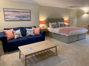 亨斯坦顿Caley的客厅配有床和蓝色沙发