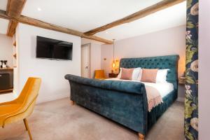 霍克赫斯特女王之旅馆的一间卧室配有一张床和一张蓝色的沙发