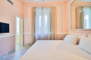 加的斯Tandem Palacio Veedor de Galeras Suites的卧室配有一张白色大床和电视。