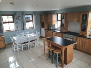 特拉利Murphys Irish Farmhouse的厨房配有桌椅、桌子和桌子。
