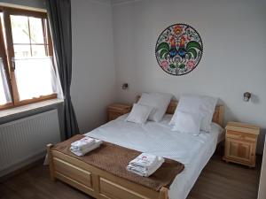 PokrzywnicaApartamenty Stajnia Ojcowizna的一间卧室配有一张床,上面有两条毛巾