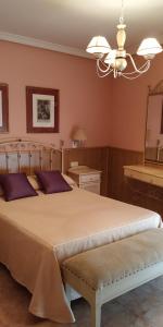 哈兰迪雅·德·拉·维尔甘特旅馆的一间卧室配有一张带紫色枕头的大床