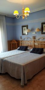 哈兰迪雅·德·拉·维尔甘特旅馆的一间卧室设有两张带蓝色墙壁和吊灯的床。