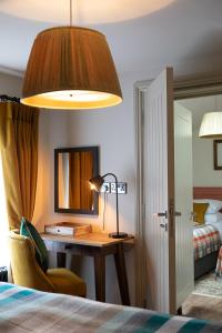 布罗肯赫斯特The Filly Inn的一间卧室配有一张桌子、一盏灯和一张床