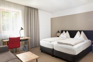 韦尔斯马斯拉以德宾馆的酒店客房配有一张床、一张书桌和一张沙发。