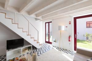 波尔图Loureiro Villas的客厅的白色楼梯,配有电视