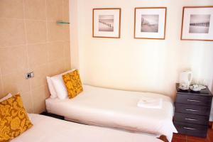 贝尼多姆唐璜旅馆的墙上有两张照片的房间的床铺