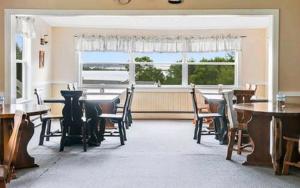 英戈尼什海滩岛上宾馆的一间带桌椅的用餐室和窗户。