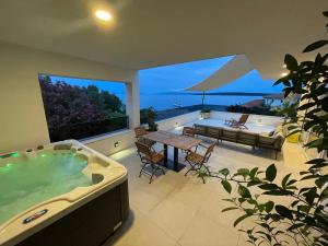 萨瓦拉Exclusive 2 Bedroom Seafront Suite with jacuzzi的一个带桌子的房子里的一个大型按摩浴缸