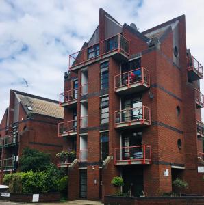 伦敦One-bedroom Rotherhithe/Bermondsey flat, Central London, UK的一座红砖建筑,设有阳台