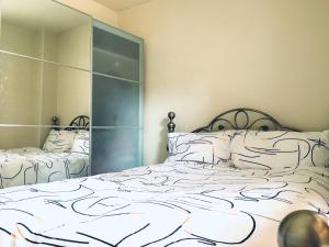 伦敦One-bedroom Rotherhithe/Bermondsey flat, Central London, UK的一间卧室设有两张床和大镜子