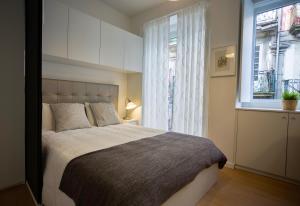 波尔图D&S - 波尔图圣本图II公寓的一间卧室设有一张大床和一个窗户。
