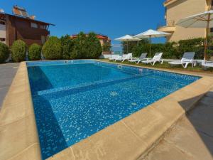 索佐波尔Hotel Odyssey Sozopol的一座房子前面的蓝色海水游泳池
