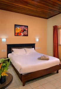 比绍Dunia Hôtel Bissau的一张位于带白色大床的房间的床铺