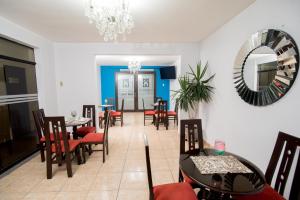 皮乌拉Hotel Casa Real Piura的一间带桌椅和镜子的用餐室