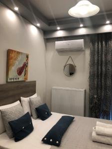 科扎尼Xenia_Apartments A2的一间卧室配有一张带蓝色枕头的床和风扇