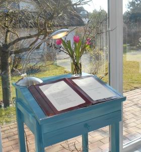 普特布斯Landhotel Kastanienallee Putbus的一张带花环和花瓶的蓝色桌子