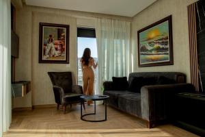 圣金Rozafa Blu Hotel的站在客厅里,望着窗外的女人