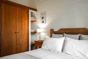 瓦勒里亚德玛瓦莱里娅豪斯出租套房旅馆的一间卧室配有一张带白色床单和木制床头板的床。