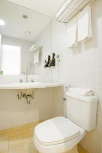马卡埃Golden Tulip Macaé的白色的浴室设有卫生间和水槽。