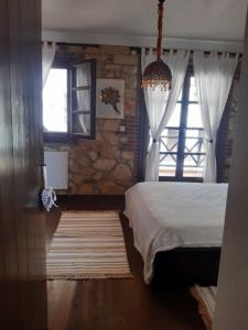 普萨克迪亚ANASTASIA STONE HOUSE的一间卧室设有一张床和一个窗口