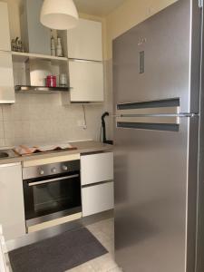 波利科罗Appartamento in Villa a Policoro的厨房配有不锈钢冰箱和白色橱柜