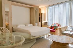 檀香山库西奥班盐酒店（带小厨房）的一间卧室配有一张床和一张玻璃桌
