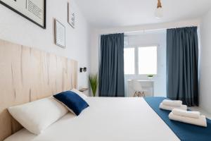 阿利坎特Casa M&J GuestHouse的卧室配有一张蓝色色调的大型白色床。