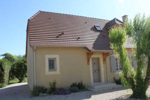 蒙蒂尼亚克Amour Périgord的棕色屋顶的黄色小房子