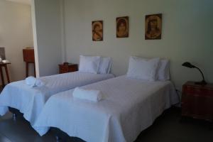 LamasIndano Art Lodge的配有2张床的客房内配有白色床单和毛巾