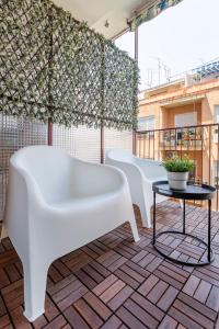 阿利坎特Casa M&J GuestHouse的阳台上的一排白色椅子和一张桌子