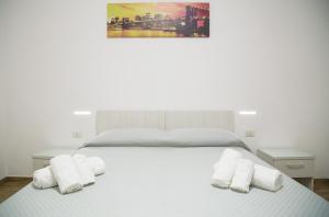 圣尼科拉阿尔切拉La Conchiglia的一张白色的床,上面有两条白色毛巾