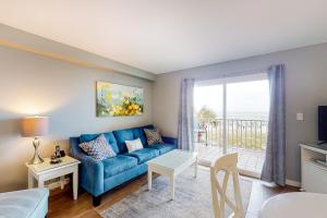格尔夫海岸Seacrest #202的一间带蓝色沙发的客厅和一个阳台