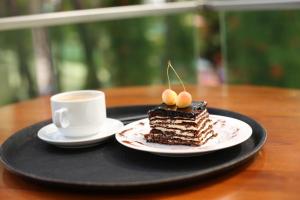 乌雷基Magnetiti Hotel的一块盘子上的蛋糕,加上一杯咖啡