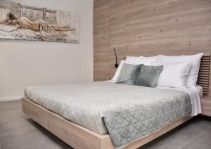 罗维尼Apartments Hidden paradise Rovinj的一间卧室配有一张大床和木制床头板