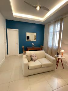 里约热内卢Point de Ipanema - 2 quartos的客厅配有白色沙发和蓝色的墙壁