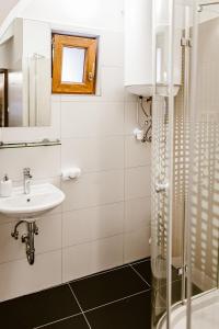 维斯普雷姆sziklavendeghaz的白色的浴室设有水槽和淋浴。