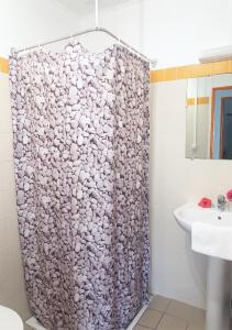 利富岛Hotel Oasis de Kiamu的一个带水槽的浴室内的淋浴帘