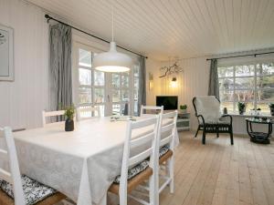 海尔斯6 person holiday home in Hals的一间配备有白色桌椅的用餐室