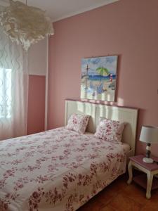莫拉尔岛Mar的卧室配有一张床,墙上挂有绘画作品