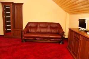 日托米尔Chalet Hotel的电视室里的棕色皮沙发