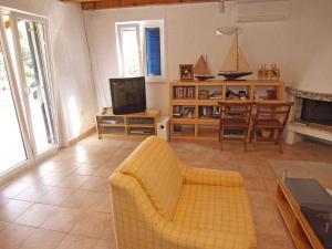 大洛希尼Holiday home in Veli Losinj 36387的客厅配有黄色沙发和电视