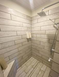 Bonne BayThe Rooms at Woody Point的带淋浴的浴室和木墙