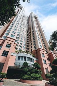 新加坡Great World Serviced Apartments的前面有树木的白色大建筑