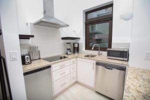 西区Bella Luna Beach Condo #227487的白色的厨房配有水槽和洗碗机